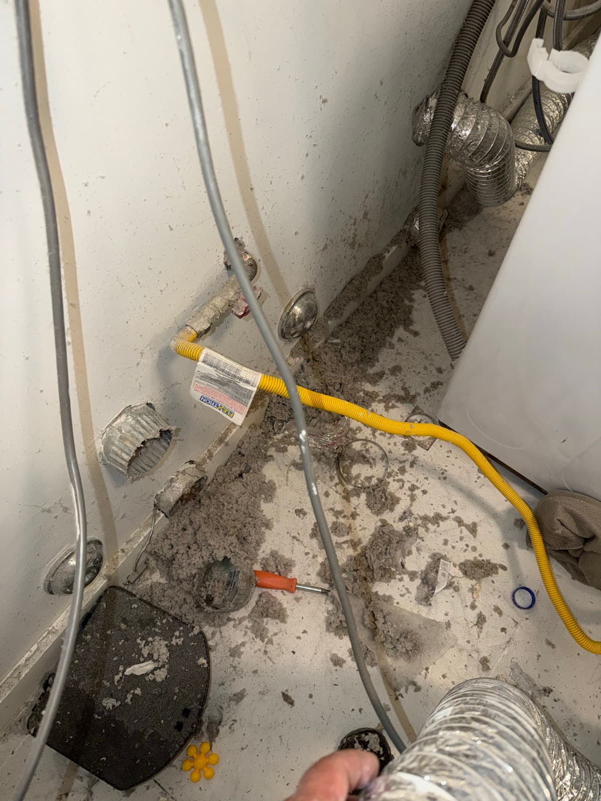 Lint and dust packed behind a dryer in a Brooklyn home before Vent Pro NYC cleaned the vent